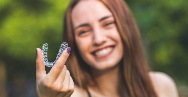 jeune femme tient dans les mains dentier invisalign