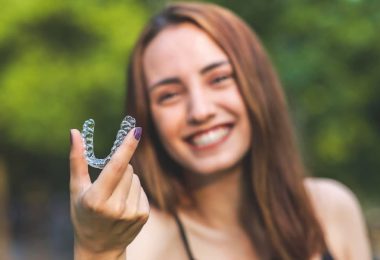 jeune femme tient dans les mains dentier invisalign